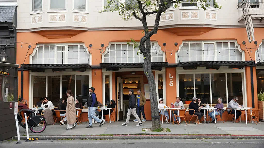People seated at tables eating outside. Photo by Brett Wharton on Unsplash.com.