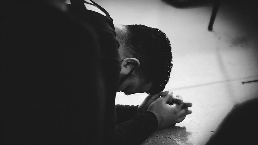 A man prostrate on the floor praying to the Lord God.