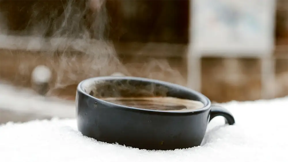 A cup of coffee on a snowy, bitter cold day